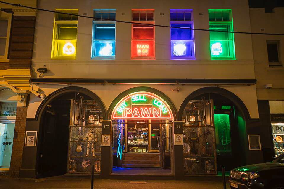 Pawn and Co's Greville Street facade illuminated in vivid neon at night